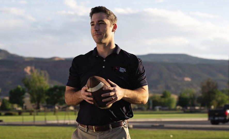 Dr. Joey Salganik holding a football outdoors in Fruita, Colorado