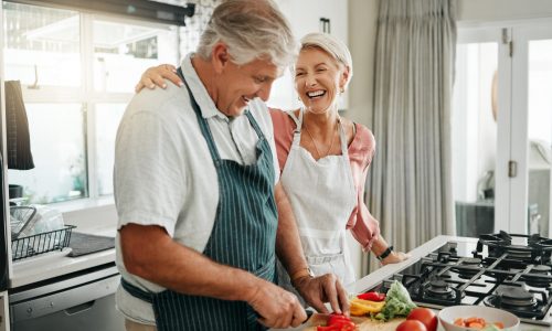Senior couple, cooking and having fun while preparing a healthy food with vegetables for a vegan me.